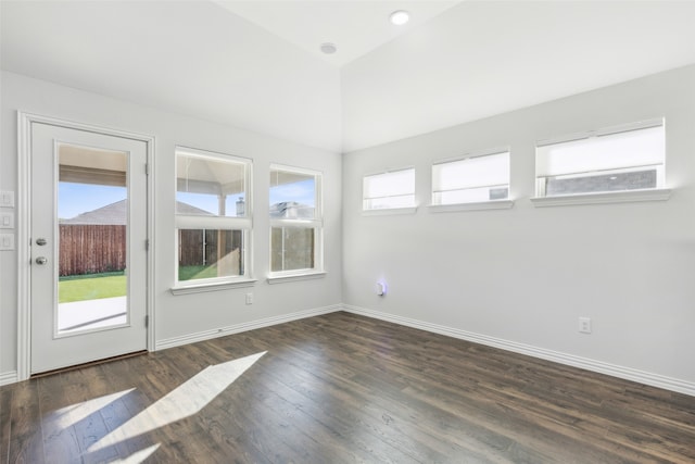 spare room featuring lofted ceiling and dark wood-type flooring