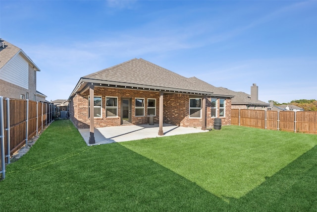 back of property with a yard, a patio area, and central air condition unit