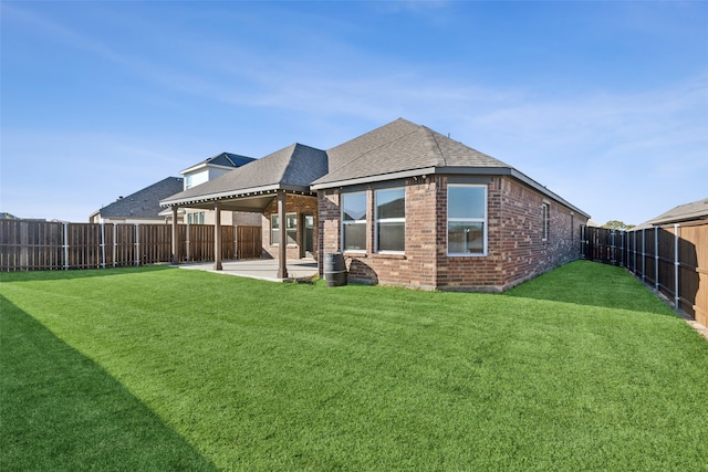 rear view of house with a lawn and a patio