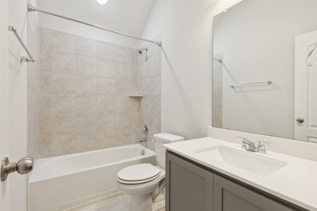 full bathroom featuring tile patterned floors, vaulted ceiling, toilet, vanity, and tiled shower / bath