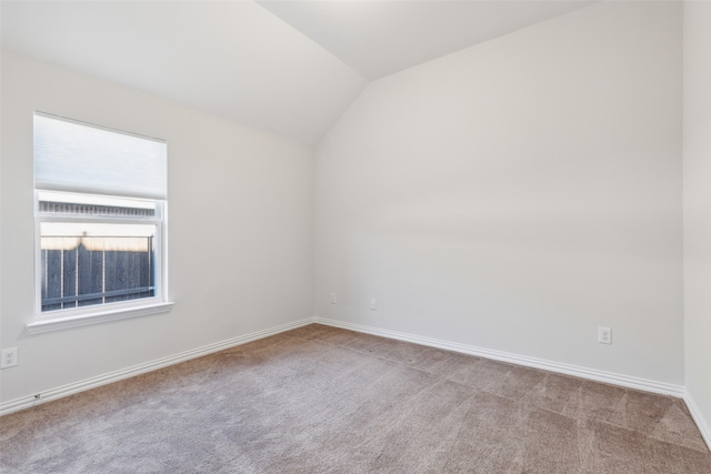 unfurnished room with light colored carpet and lofted ceiling