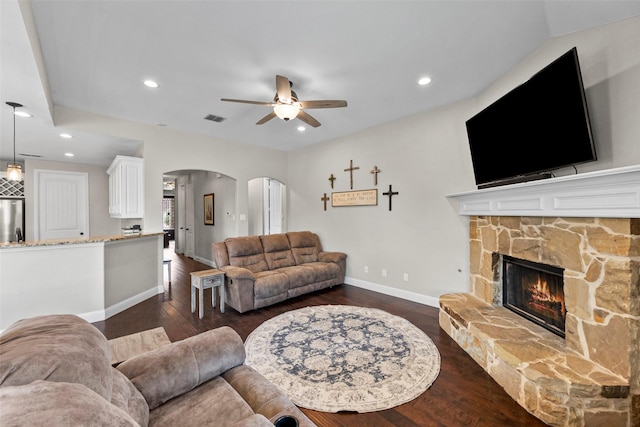 living room featuring dark hardwood / wood-style flooring, a fireplace, and ceiling fan