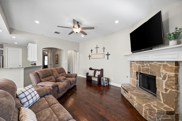 living room with dark hardwood / wood-style flooring, a fireplace, and ceiling fan