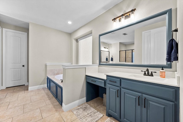 bathroom with tile patterned floors, a bath, and vanity