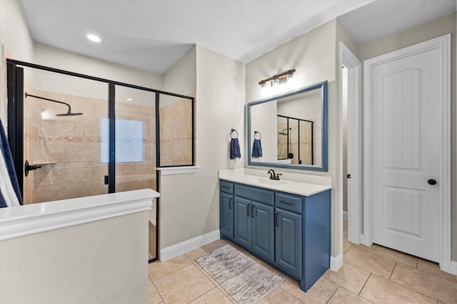 bathroom with tile patterned floors, vanity, and a tile shower