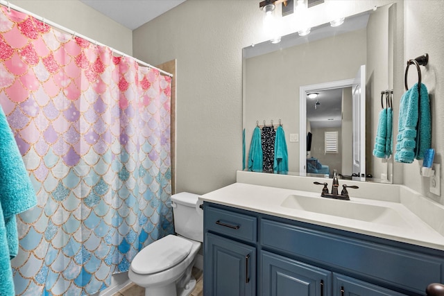 bathroom with vanity, curtained shower, and toilet