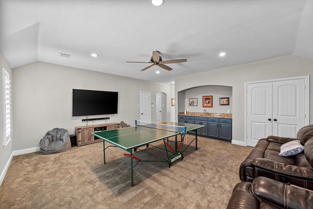 recreation room with lofted ceiling, light colored carpet, ceiling fan, and indoor wet bar