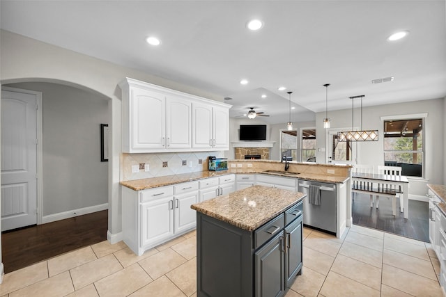 kitchen featuring white cabinetry, hanging light fixtures, stainless steel dishwasher, and kitchen peninsula