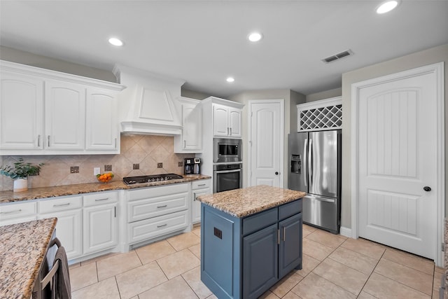 kitchen with light stone counters, stainless steel appliances, and a center island