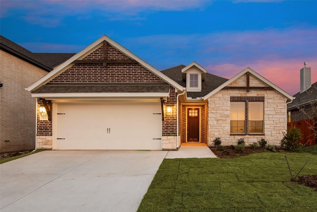 view of front of house with a shingled roof, a front yard, driveway, stone siding, and an attached garage