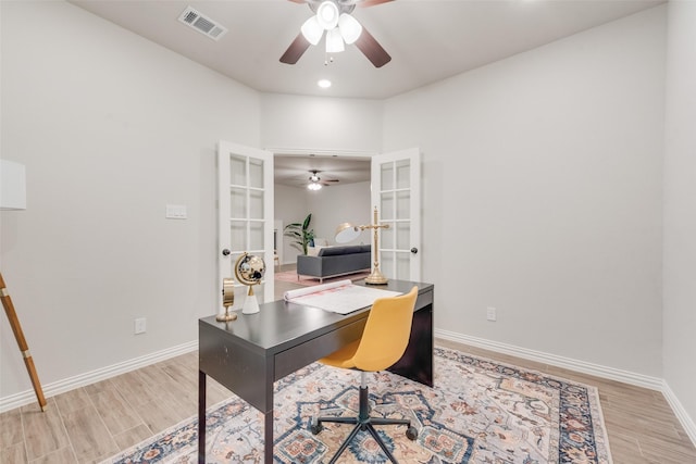 office featuring visible vents, baseboards, light wood-style flooring, ceiling fan, and french doors