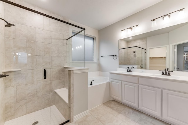 full bath with double vanity, a shower stall, a garden tub, and a sink