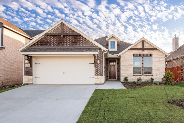 view of front of house featuring stone siding, concrete driveway, a front yard, a shingled roof, and a garage