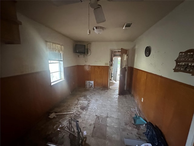 misc room featuring wooden walls and ceiling fan