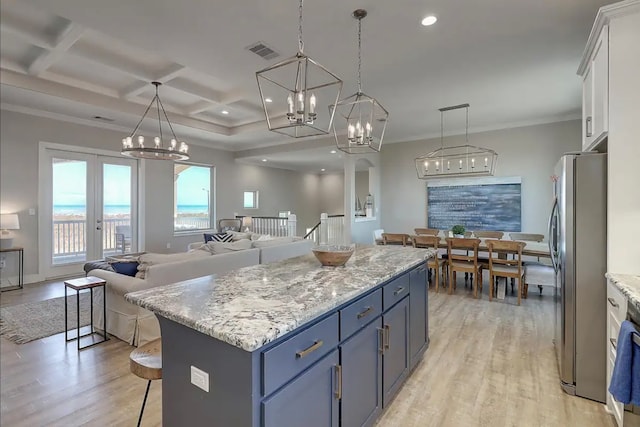 kitchen featuring pendant lighting, light hardwood / wood-style floors, white cabinetry, and stainless steel refrigerator