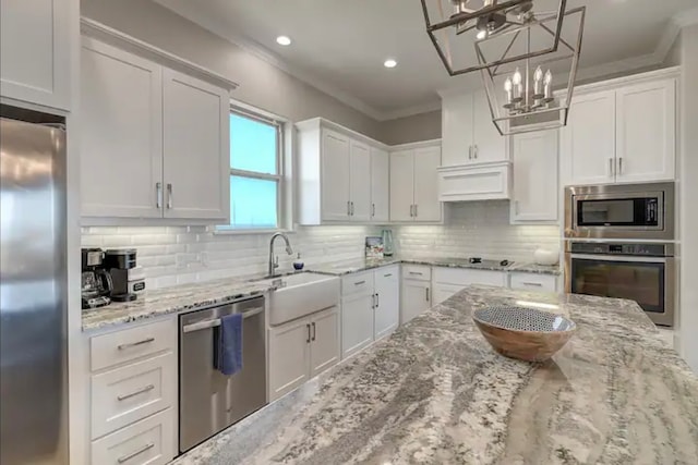 kitchen featuring white cabinets, appliances with stainless steel finishes, and pendant lighting