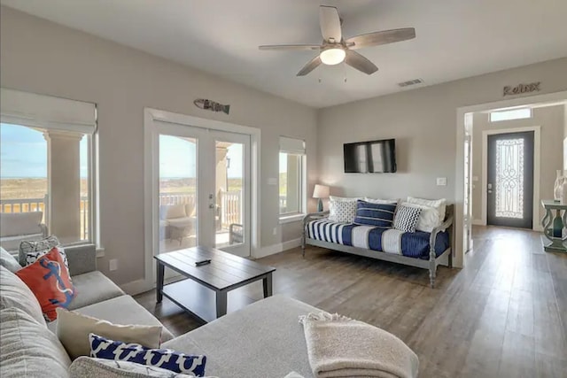 living room featuring hardwood / wood-style floors, ceiling fan, french doors, and a healthy amount of sunlight