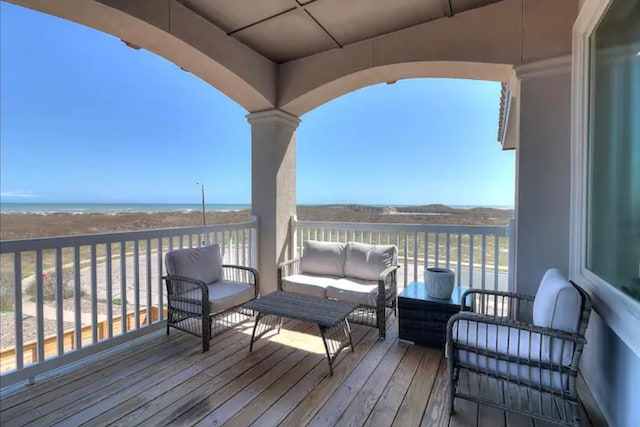 deck with an outdoor living space and a water view