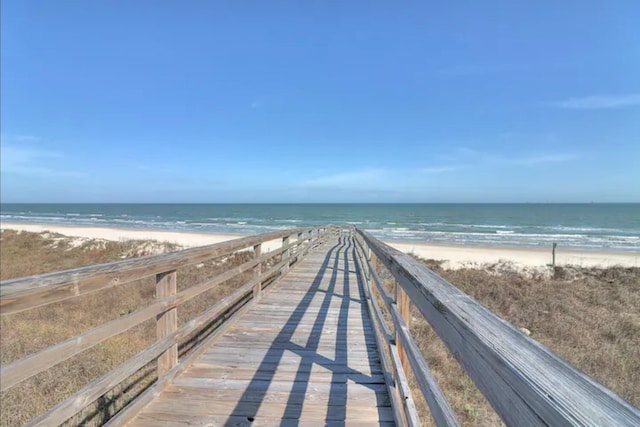 view of community with a water view and a beach view