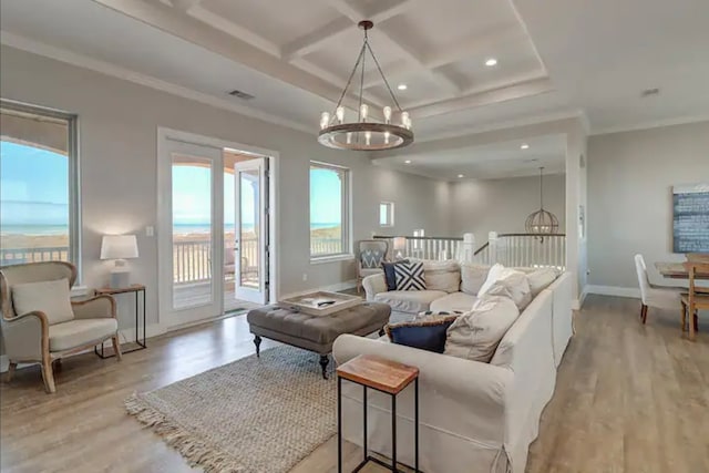 living room with ornamental molding, light hardwood / wood-style floors, and a notable chandelier