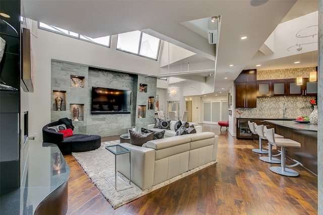 living room with dark hardwood / wood-style floors, sink, and vaulted ceiling