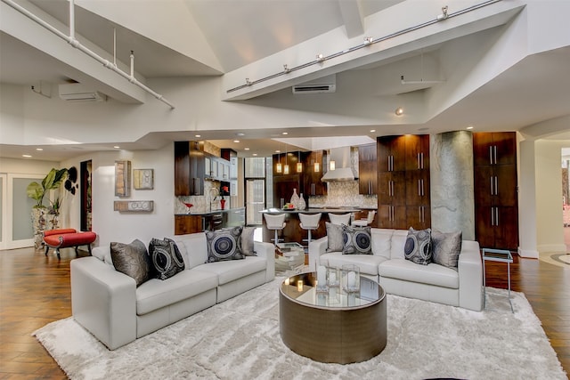 living room with dark hardwood / wood-style flooring, a high ceiling, and a wall mounted AC