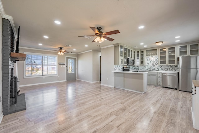 kitchen featuring tasteful backsplash, ornamental molding, stainless steel appliances, and light hardwood / wood-style flooring