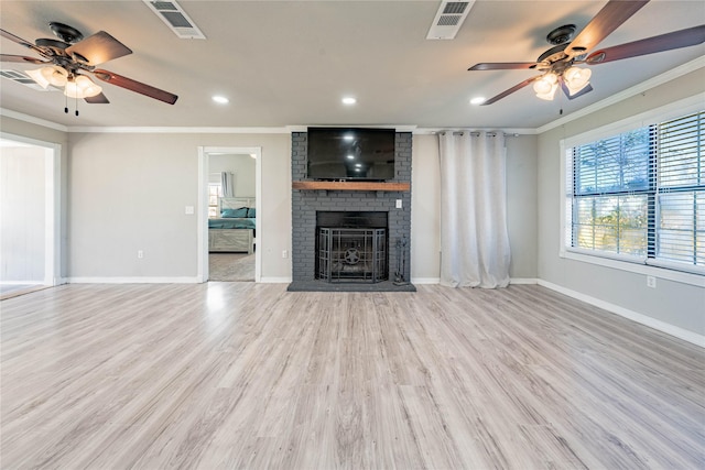 unfurnished living room with a brick fireplace, light hardwood / wood-style flooring, ceiling fan, and crown molding