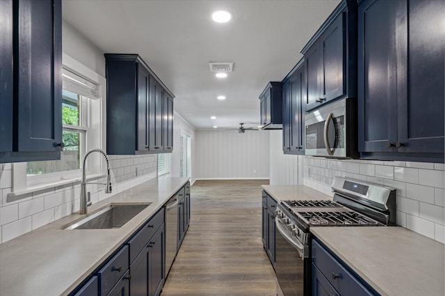 kitchen featuring backsplash, dark wood-type flooring, sink, ceiling fan, and appliances with stainless steel finishes