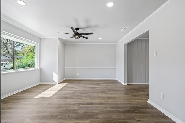 empty room featuring ceiling fan, crown molding, and dark wood-type flooring