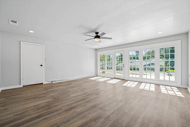 spare room with dark hardwood / wood-style floors, ceiling fan, and a textured ceiling