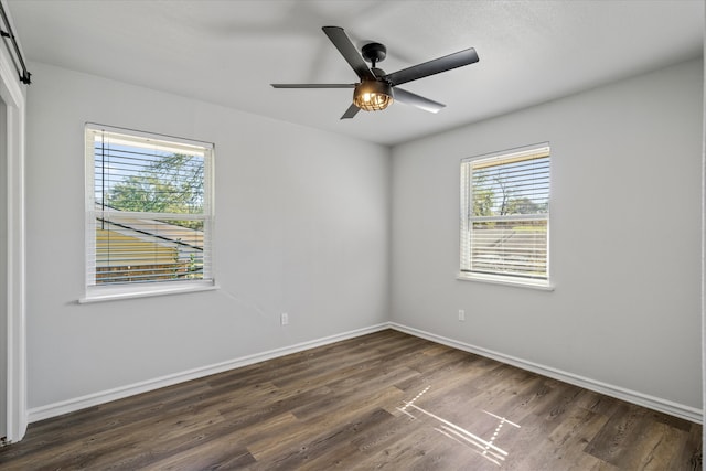 empty room featuring dark hardwood / wood-style flooring and ceiling fan