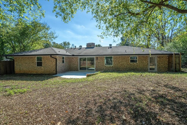 back of property with a lawn and a patio