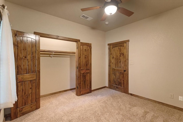 unfurnished bedroom featuring light colored carpet, a closet, and ceiling fan