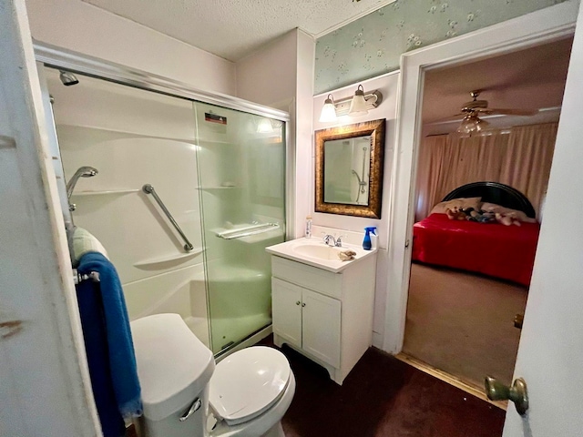 bathroom featuring ceiling fan, a textured ceiling, vanity, and walk in shower