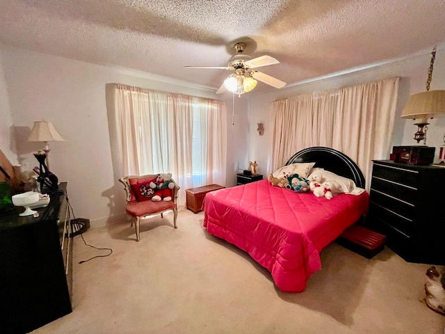 carpeted bedroom featuring ceiling fan and a textured ceiling