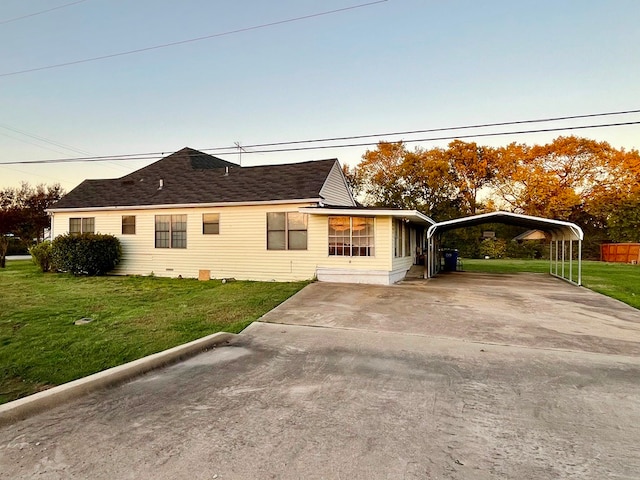 view of home's exterior with a lawn and a carport