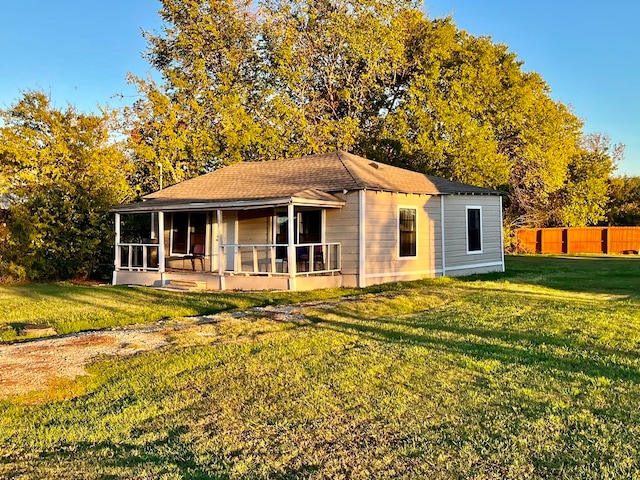 rear view of house featuring a yard