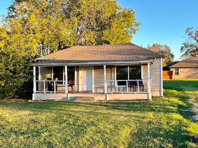 rear view of property with a yard and a porch