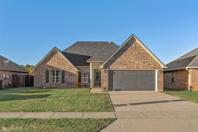 view of front of home with a garage and a front lawn