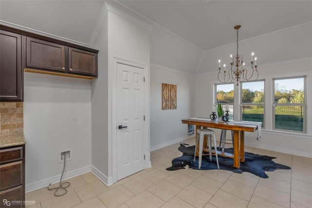 dining room with crown molding, light tile patterned flooring, a chandelier, and vaulted ceiling