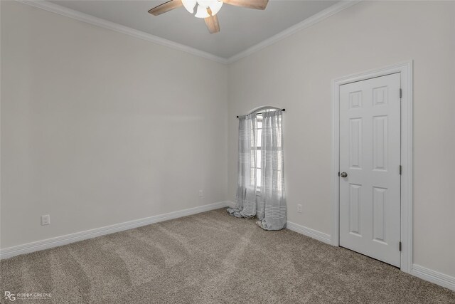 carpeted spare room featuring ceiling fan and crown molding