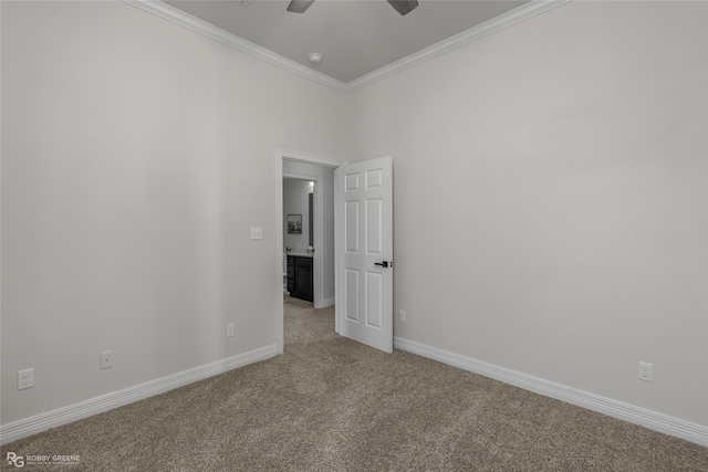 carpeted spare room featuring ceiling fan and ornamental molding