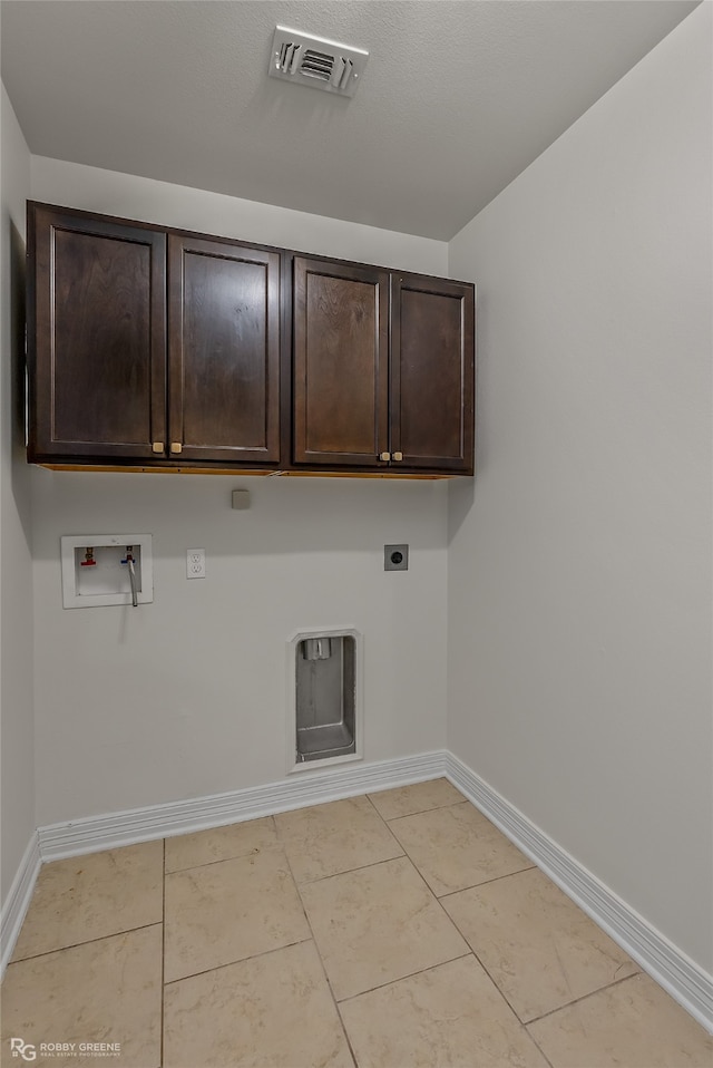 washroom featuring hookup for an electric dryer, washer hookup, light tile patterned floors, and cabinets