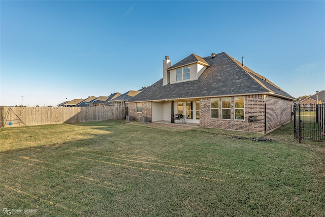 back of house with a yard and a patio area