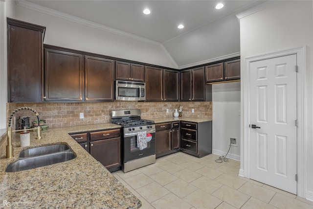 kitchen featuring light stone counters, sink, lofted ceiling, and appliances with stainless steel finishes