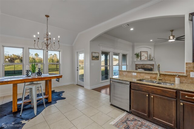 kitchen featuring dishwasher, light stone counters, a healthy amount of sunlight, and sink