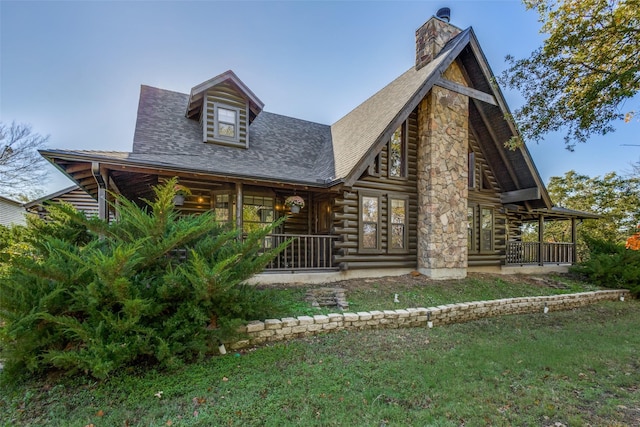 log-style house featuring a front lawn and covered porch