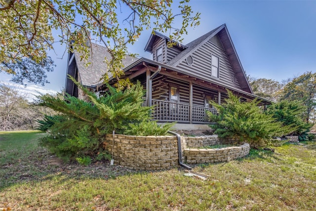 log cabin featuring a porch and a front lawn