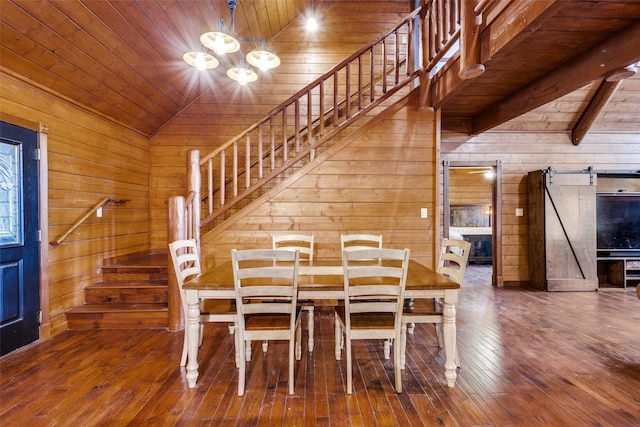 unfurnished dining area featuring wood ceiling, wooden walls, and a barn door